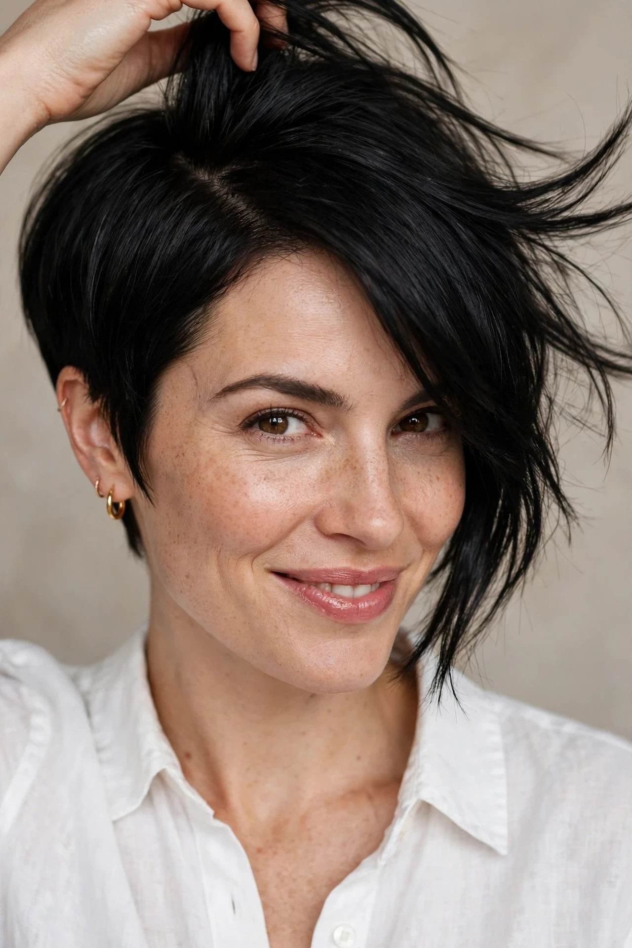 Woman flipping the part on an asymmetrical pixie bob
