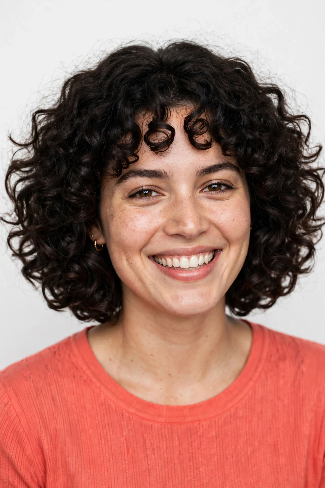 Voluminous dark curly hair grown into a rounded lob shape